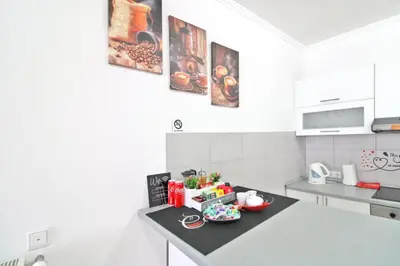 a white kitchen with a counter with food on it at Apartman Slani San in Tuzla