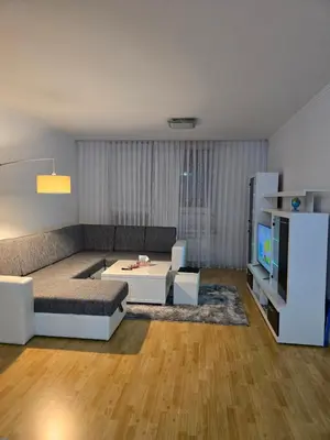 a living room with a couch and a table at Apartman Slani San in Tuzla