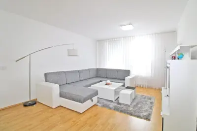 a living room with a couch and a table at Apartman Slani San in Tuzla