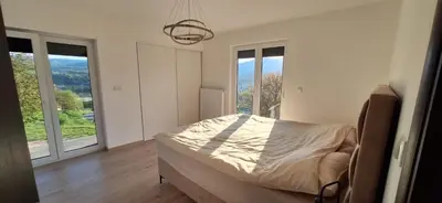 a bedroom with a bed in a room with windows at Villa Alyanna in Rankovići