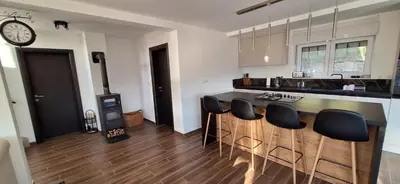 a kitchen with a counter and some black chairs at Villa Alyanna in Rankovići