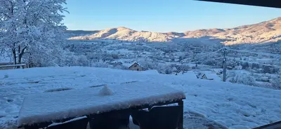 a snow covered roof of a house with mountains in the background at Villa Alyanna in Rankovići