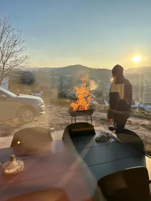 a man standing next to a fire in a field at Villa Alyanna in Rankovići