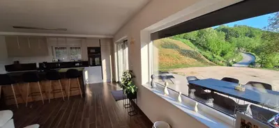 a kitchen with a table and a large window at Villa Alyanna in Rankovići