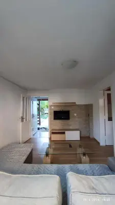 a living room with two beds and a television at Apartmani Elix II in Ivišovo Greblje