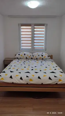 a bedroom with a bed with a comforter and pillows at Apartmani Elix II in Ivišovo Greblje