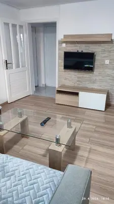 a living room with a tv and a glass table at Apartmani Elix II in Ivišovo Greblje