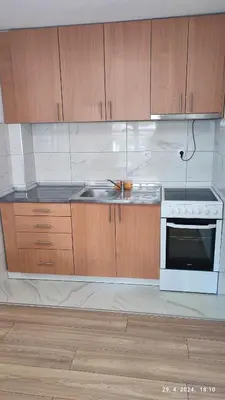 a kitchen with a sink and a stove and cabinets at Apartmani Elix II in Ivišovo Greblje