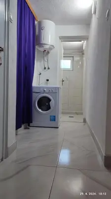 a bathroom with a washing machine in a room at Apartmani Elix II in Ivišovo Greblje