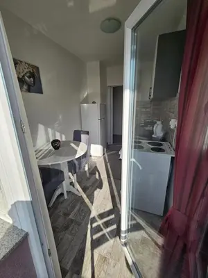 a small kitchen with a table and a refrigerator at Apartman Annie in Bihać