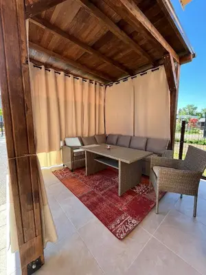 a patio with a couch and a table and chairs at Apartman Dar in Bihać