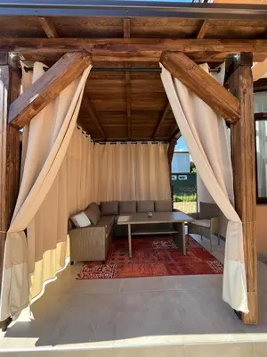 a living room with a couch and curtains at Apartman Dar in Bihać