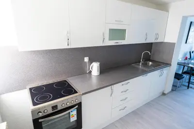a kitchen with white cabinets and a stove top oven at Apartman 11 in Tomislavgrad
