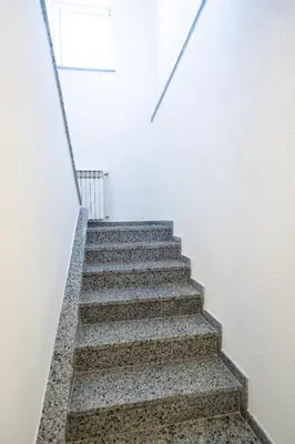 a stair case in a white room with stairs at Apartman 11 in Tomislavgrad