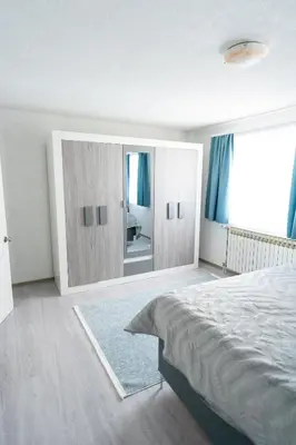 a bedroom with a large bed and a large mirror at Apartman 11 in Tomislavgrad