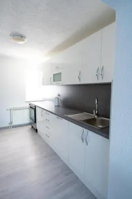 a white kitchen with a sink and white cabinets at Apartman 11 in Tomislavgrad