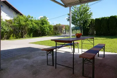 a table and two stools sitting under an umbrella at Villa Plavno in Otoka