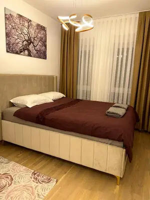 a bedroom with a large bed with a brown blanket at Stan Tesanj in Tešanj