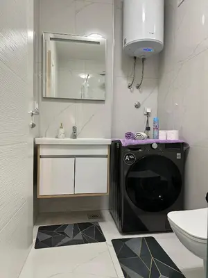 a bathroom with a washing machine and a sink at Stan Tesanj in Tešanj