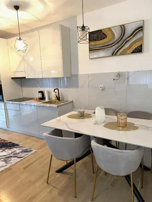 a kitchen with a white table and chairs at Stan Tesanj in Tešanj