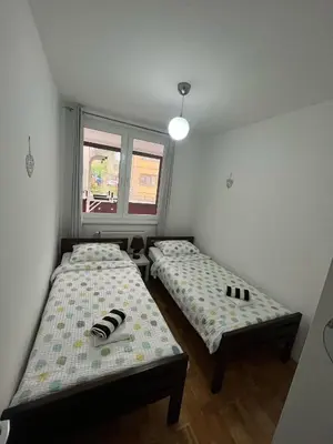two beds in a small room with a window at Apartman Filip in Jajce