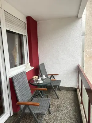 a small balcony with two chairs and a table at Apartman Filip in Jajce