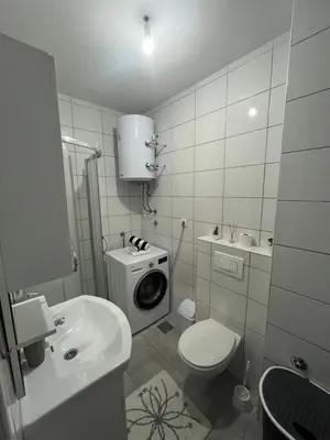 a bathroom with a washing machine and a toilet at Apartman Filip in Jajce