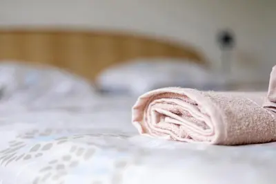 a pink towel laying on a bed at Apartman D&A in Brekovica