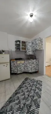 a kitchen with a white refrigerator and a rug on the floor at Apartman D&A in Brekovica