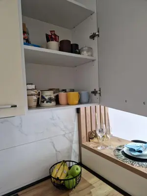 a kitchen with a table with a basket of fruit at Apartman Eden in Doboj