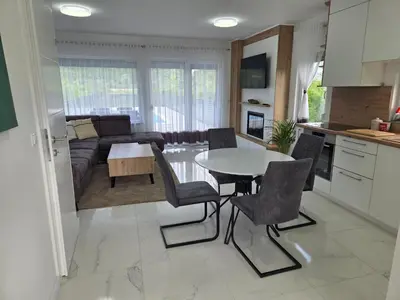 a kitchen and living room with a table and chairs at Villa Alisa in Bihać