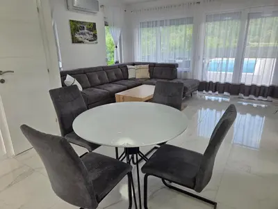 a living room with a table and chairs and a couch at Villa Alisa in Bihać