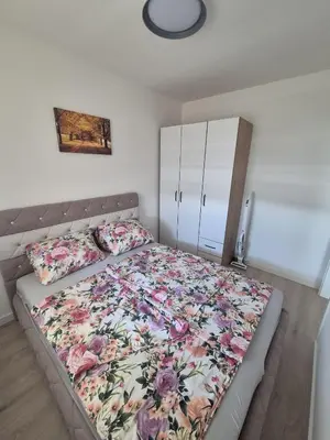 a bedroom with a large bed with a floral bedspread at Apartman Centar 8 Doboj in Doboj