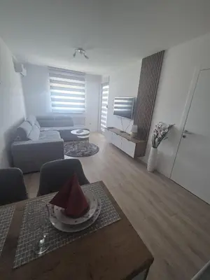 a living room with a couch and a table at Apartman Centar 8 Doboj in Doboj