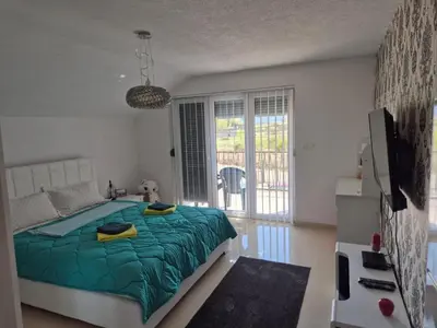 a bedroom with a bed with a green comforter at Apartman IN in Bihać