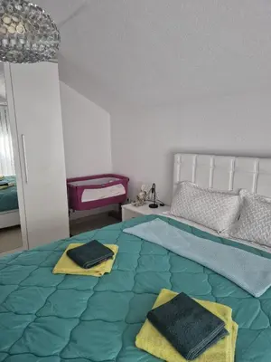 a bedroom with a bed with two towels on it at Apartman IN in Bihać