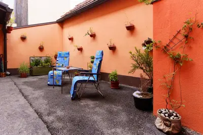 a patio with two blue chairs and a table at Apartman Elyca in Visoko
