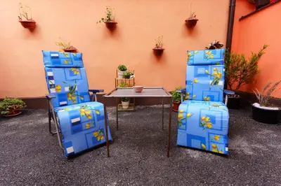three blue chairs and a table in front of a wall at Apartman Elyca in Visoko