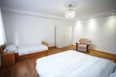 a bedroom with two beds and a chair in it at Apartman Elyca in Visoko