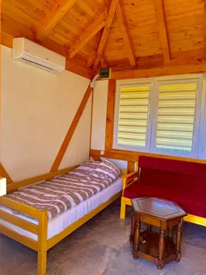 a bedroom with a bed and a bench in a room at Nedzad Barrel Apartments in Visoko