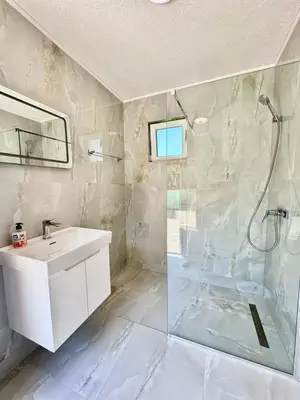 a white bathroom with a sink and a shower at Nedzad Barrel Apartments in Visoko