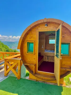 a wooden circular building with a large window on a deck at Nedzad Barrel Apartments in Visoko