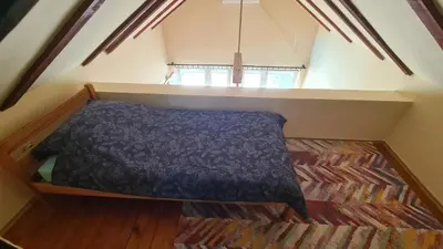 a small attic bedroom with a bed in the attic at Vikendica Mala Priča in Srebrenik