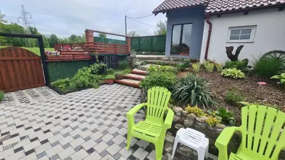 two green chairs sitting on a patio in front of a house at Vikendica Mala Priča in Srebrenik