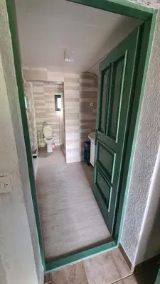 a bathroom with a green door and a toilet at Vikendica Mala Priča in Srebrenik