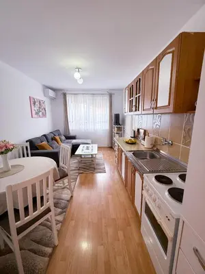 a kitchen and living room with a couch and a table at A Cozy Nest in Teslic in Teslić