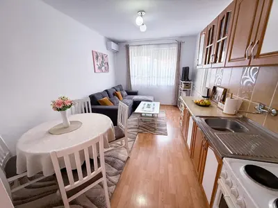 a kitchen and living room with a table and a couch at A Cozy Nest in Teslic in Teslić