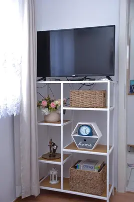 a tv on a white shelf with a television at A Cozy Nest in Teslic in Teslić