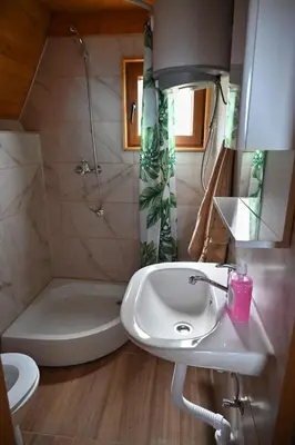 a bathroom with a sink and a tub and a toilet at Bungalovi Potočarska panorama in Mrkonjić Grad