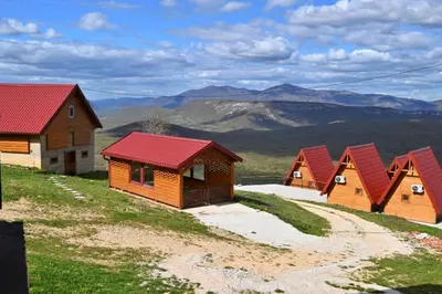 a row of wooden cabins on top of a mountain at Bungalovi Potočarska panorama in Mrkonjić Grad